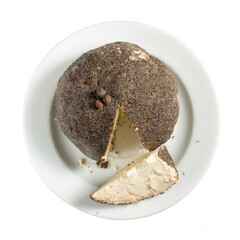 Belper Knolle - Swiss cheese. Cheese ball sprinkled with black pepper on white plate isolated on white background. Top view.