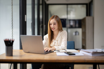 Business woman sitting and working using laptop, searching and checking information