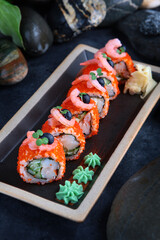 Rolls and sushi. Rolls with shrimp, tobiko caviar and cucumber. Traditional Japanese cuisine.Vertical photo.