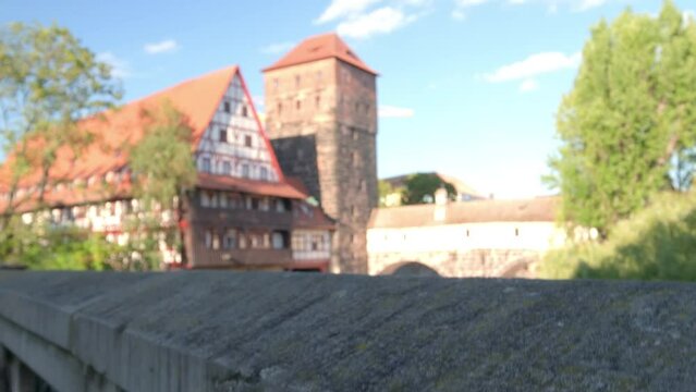 Camera rises on Maxbrucke to reveal Wasserturm and River Pegnitz on a sunny summer day in Nuremberg, Germany 