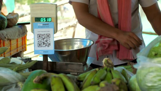 The vegetable vendor measuring fresh tomatoes in a measuring machine - vegetable stall  use of polythene  single-use plastic in India. Street sellers selling vegetables - street market  scanner  pa...