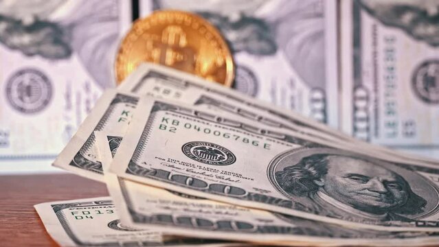Close-up of man counting out dollars for bitcoins. Bitcoin coin, digital gold next to hands of expert trader counting profitable banknotes in form dollar cash. Cryptocurrency