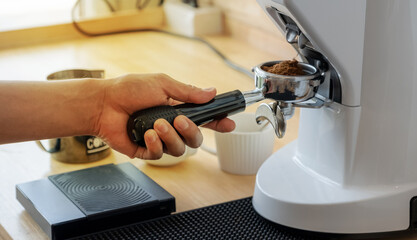 Barista hand hold manual presses tamper and portafilter make coffee in cafe coffee shop