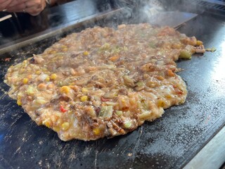 鉄板の上でもんじゃ焼きを焼く