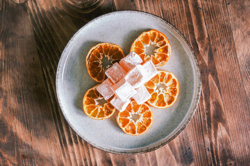 Dried mandarin or tangerine slices with mandarin flavored Turkish delight on a wooden table. Seferihisar local flavors. Dried orange. Citrus fruit
