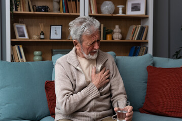 Elderly aged senior man sitting alone in the dark of his apartment depressed and sad after the loss...