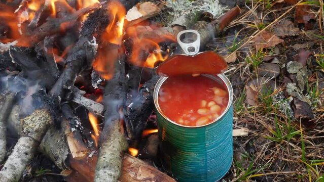 cooking ready-to-eat canned food by the lake