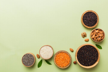Various superfoods in smal bowl on colored background. Superfood as rice, chia, quinoa, lentils, nuts, sesame seeds, almonds. top view copy space