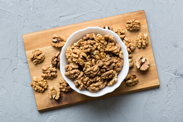 Fresh healthy walnuts in bowl on colored table background. Top view Healthy eating bertholletia concept. Super foods