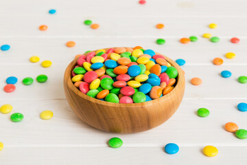 Multicolored candies in a bowl on a colored background. birthday and holiday concept. Top view with...