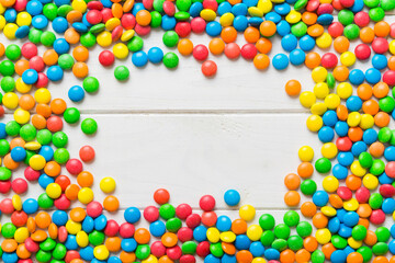 Mixed collection of colorful candy, on colored background. Flat lay, top view. frame of colorful chocolate coated candy