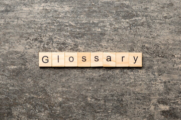 glossary word written on wood block. glossary text on table, concept