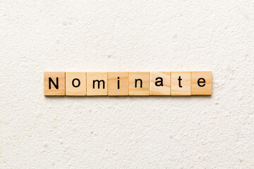 nominate word written on wood block. nominate text on table, concept