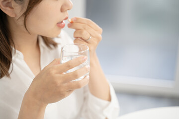薬を飲む女性