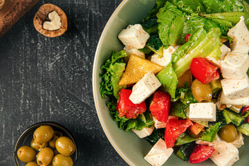 Portion of fresh greek salad on grey background