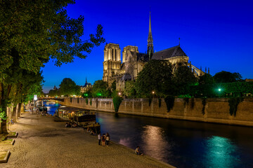 Night view of Cathedral Notre Dame de Paris, island Cite and river Seine in Paris, France....