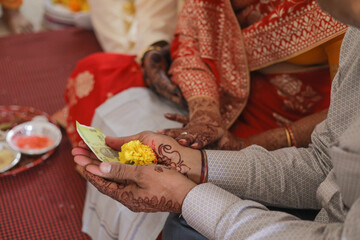 Indian wedding rituals of bride and groom holding their hands with flower in hand ,India wedding 

