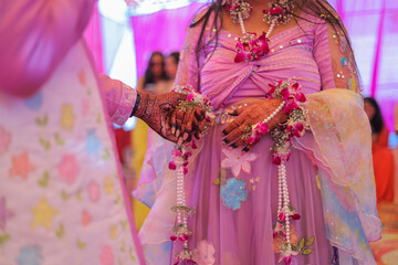 Indian wedding candid photo of groom and bride holding hand 
