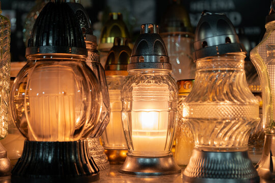 Cemetery grave candle glass lanterns, znicz illuminated at night. Memorial light remembrance snitch. All Saints' Day, Feast of All Souls or the Day of the Dead.