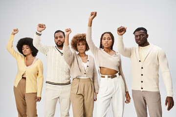 Juneteenth and activism, happy african american people with clenched fists on grey background - obrazy, fototapety, plakaty