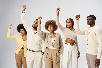 Juneteenth concept, happy african american people standing with clenched fists on grey background