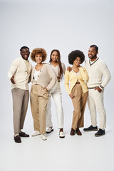 Obraz premium group of young african american men and women posing with hands in pockets on grey background