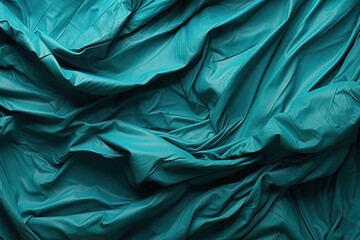  a close up of a teal colored sheet on a bed with a pillow on top of it and a pillow on the side of the bed and a pillow on the other side of the bed.