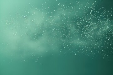  a blurry photo of water droplets floating in the air on a blue and green background with a white cloud in the middle of the picture and bottom right corner of the image.