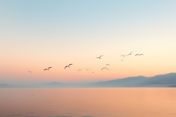  a flock of birds flying over a large body of water with a mountain range in the background at sunset or sun set in the middle of the sky above the water.