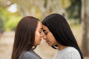 Latin women lesbian couple touching face to face showing love and emotions