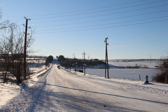 A snowy road with power lines