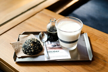 Someone’s hand pouring coffee to milk glass
