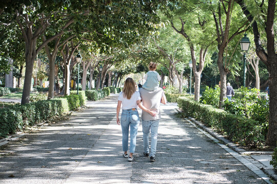 Pareja paseando por el parque en familia 