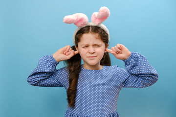 Portrait of naughty preteen girl child wearing pink fluffy easter bunny ears covering ears with...