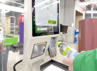 Customer pays his purchase at the supermarket,self checkout systems in  retail stores,Barcode scanner,Self checkout machine