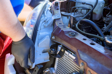 During car repair, mechanic assembles headlights of vehicle