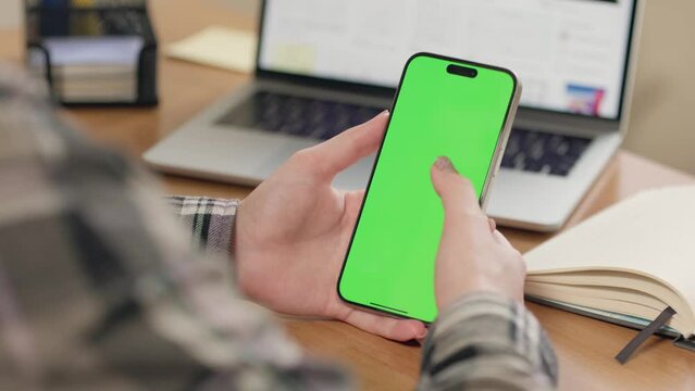 Close-up Of Young Woman In Glasses Using Mobile Phone With Vertical Green Screen In Office Or At Home