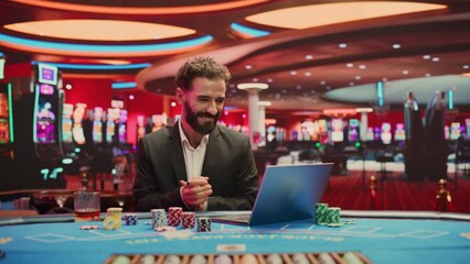 Portrait of Young Man on Casino Floor, Using Laptop Computer to Play Online Casino Betting Jackpot Games. Professional Businessman Celebrating Winning Jackpot Bet. Luck and Strategy. Vibrant Edit