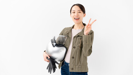 ヘルメットを抱えてピースする女性