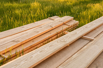 Solid-sawn lumber, sawn timber, solid wood.  Wood materials on green lawn or grass outdoors