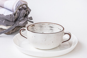 a wicker basket, a ceramic  soup bowl  on white background. Home atmosphere, kitchen dishware, product display or design key visual layout.