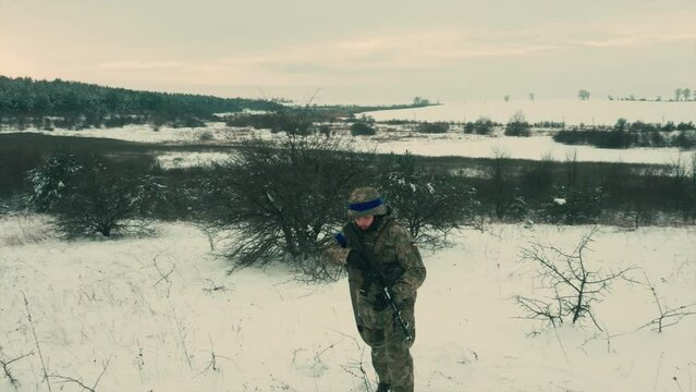 A soldier of the Ukrainian army walks slowly through the snowy terrain. Ukraine's fault with Russia. Resistance to the aggressor.Russian war.