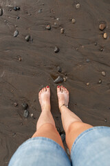 Women feet splashing and walking on the beach with red nail polish 