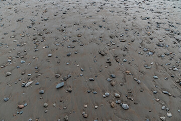 Beach with stones pebbles in dark sand Dominical Costa Rica