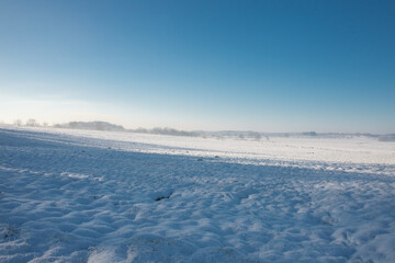 Fototapeta na wymiar Norddeutsche Landschaft, schneebedeckt und friedlich an einem frühen Morgen in Kälte und Dunst