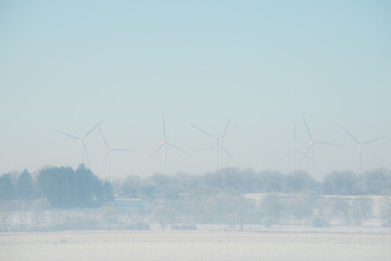 Ein diesiger Wintermorgen mit Blick über Felder, Wälder und Windräder