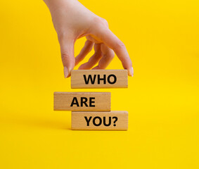 Who are You symbol. Concept words Who are You on wooden blocks. Businessman hand. Beautiful yellow...