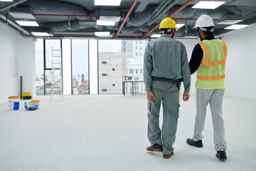 Foreman and builder checking office building under construction