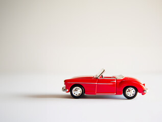 Red Convertible Vintage Toy Car on a Minimalist White Background with Copy Space