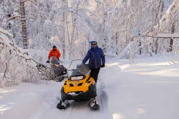 Woman on a snowmobile moving in the winter forest in the mountains of the Southern Urals